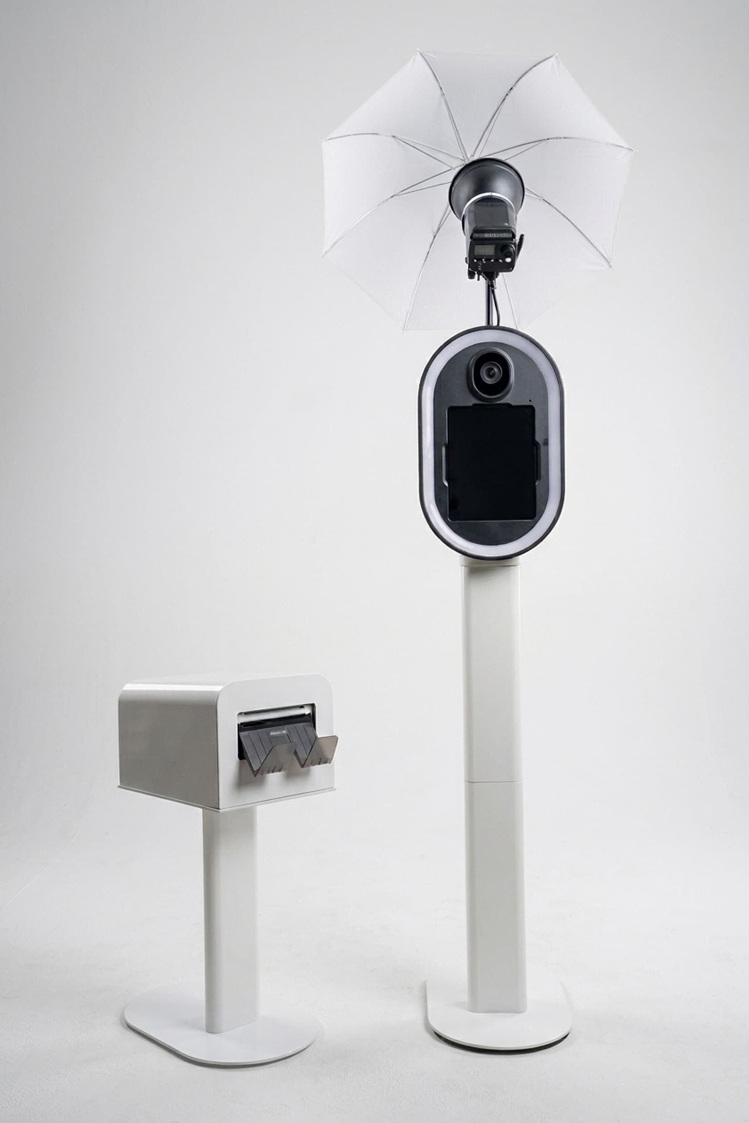 the open-air photo booth under its studio flash and umbrella, beside the print station on its own stand