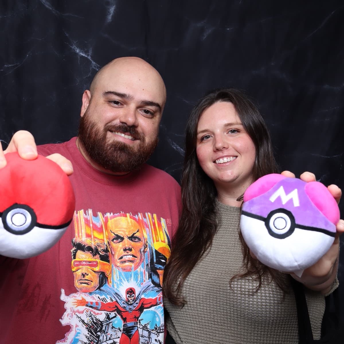 a couple showing off oversized plush props