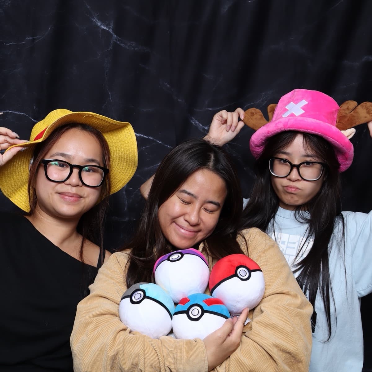 three friends in prop hats holding their finds